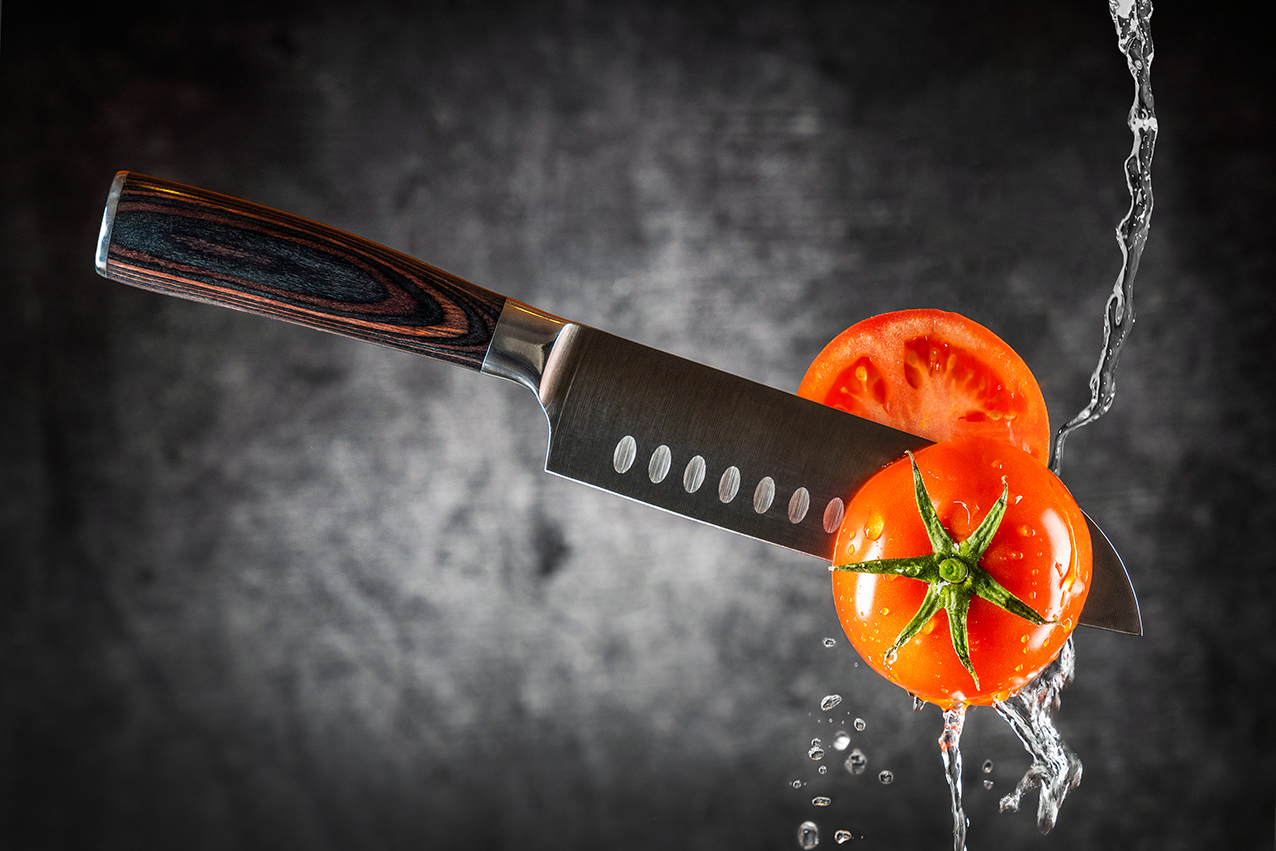 scharfes Messer schneidet durch Tomate